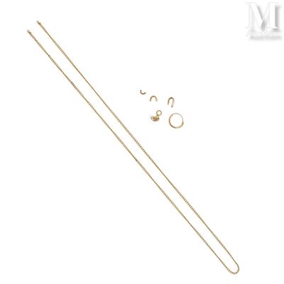 un gros plan sur une chaîne en or à laquelle sont accrochées une paire de boucles d'oreilles