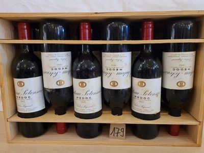 des bouteilles de vin rouge sont alignées dans une caisse en bois