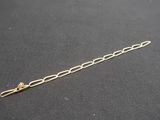 a close up of a gold chain bracelet on a black surface
