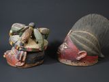 pair of african masks on a black background with a dark background