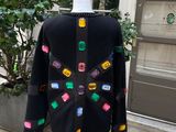 the back of a black sweater with multicolored buttons on it