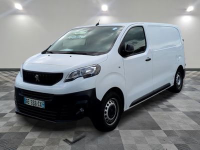 la camionnette blanche est garée dans une grande pièce au sol en damier