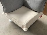 a chair that has a pillow on it in a room