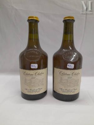 two bottles of wine sitting on top of a table next to each other