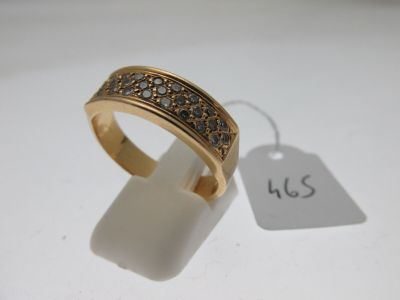 gros plan d'une bague en or avec des diamants sur une surface blanche