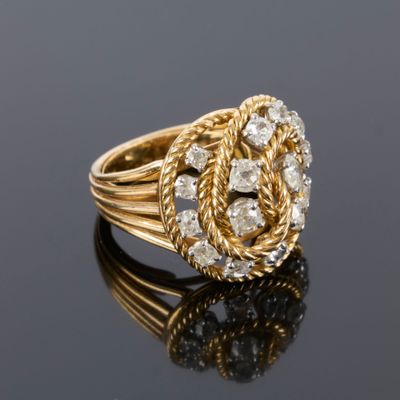 a gold and diamond ring with a knot around the center