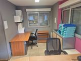 une pièce avec un bureau, une chaise et une fenêtre