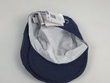 un chapeau bleu marine et blanc posé sur une table blanche, sur fond blanc