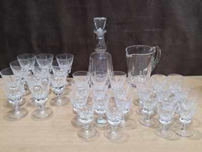 plusieurs verres et une carafe posés sur une table