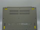 the back side of a laptop with a yellow button on it