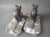 two figurines of cats sitting on top of each other