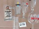 de nombreux verres et tasses exposés sur une étagère