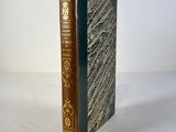 an old book sitting on top of a white table next to a white wall