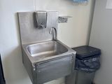 un lavabo et une poubelle dans un coin de la salle de bains