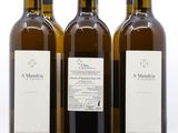 trois bouteilles de vin posées les unes à côté des autres sur une surface blanche