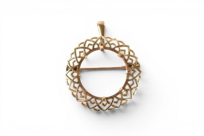 a close up of a gold plated brooch with a circular design