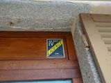 une pancarte sur la porte d'un immeuble sur laquelle est inscrit « TV »