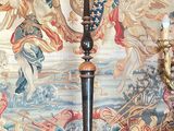une lampe posée sur une table devant une tapisserie