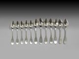 six cuillères en argent sont alignées sur une table
