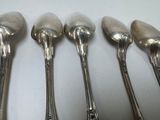 six spoons are lined up in a row on a table