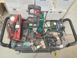 un chariot rempli d'outils électriques posé par terre