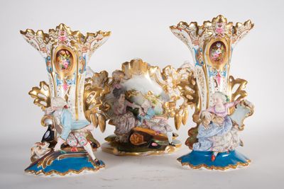 three vases with figurines on them sitting on a table