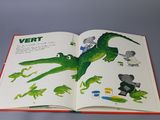 an open book with a picture of a dinosaur and other animals