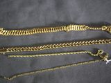 three different types of gold chains on a black background