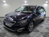 la voiture noire est garée sur un sol en damier dans le garage