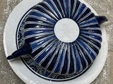 a blue and white plate with a teapot on it