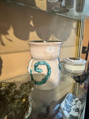 une vitrine en verre remplie de vases et d'autres objets décoratifs