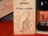 a bottle of wine in a wooden box with a signed label
