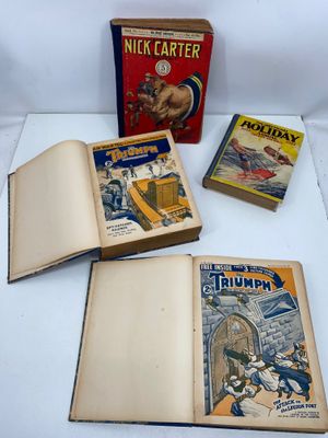 trois livres sont posés sur une table à côté d'une boîte remplie de livres