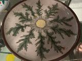 a plate with a flower on it sitting on a glass table