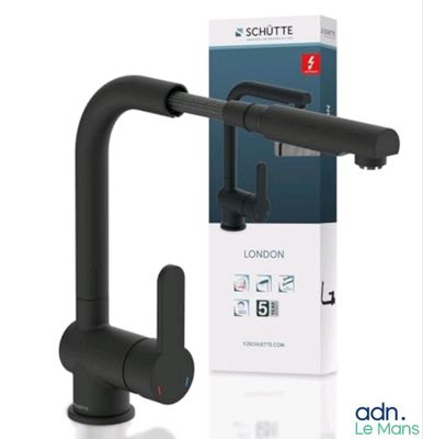 un gros plan sur un robinet noir avec une boîte en arrière-plan