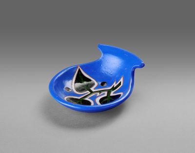 a blue bowl with a bird on it sitting on top of a table