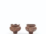 two small wooden vases sitting next to each other on a white surface