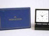 une horloge posée devant une boîte bleue