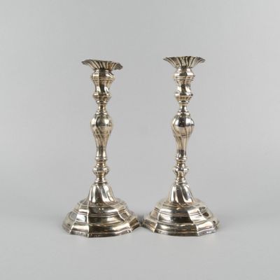 a pair of silver candlesticks on a white background