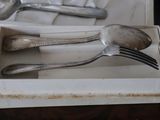 two silver spoons and two silver spoons in a box