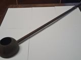 a pipe on a table with a wooden handle on it