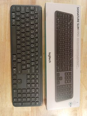 un clavier noir et une boîte blanche posés sur une table en bois