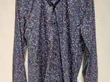blue shirt with white stars on it hanging on a hanger