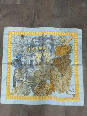 a close up of a blue and yellow scarf on a wooden floor