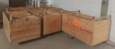 Plusieurs caisses en bois sont empilées les unes sur les autres dans un entrepôt