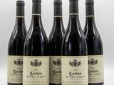 quatre bouteilles de vin sont alignées sur une surface blanche