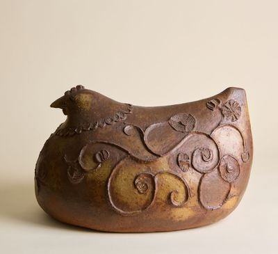 un oiseau brun perché sur un vase brun