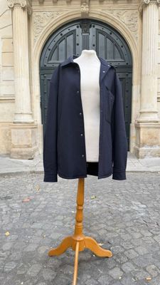 un mannequin devant un immeuble, vêtu d'un manteau