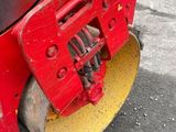 a close up of a red machine on the ground