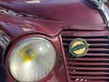 a close up of a red car with a green emblem on it